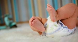 bebe acostado con las piernitas levantadas usando pañal biodegradable