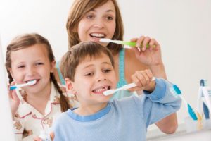 Mamá con sus hijos lavándose los dientes