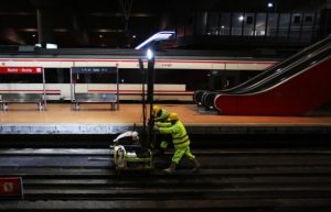 Personas trabajando de noche en vías de tren