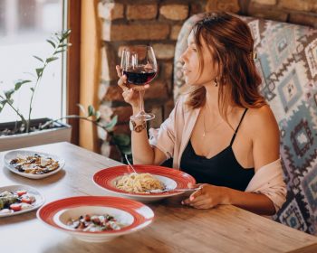 mujer disfrutando vino en restaurante italiano
