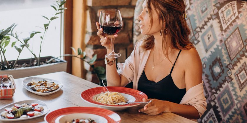 mujer disfrutando vino en restaurante italiano