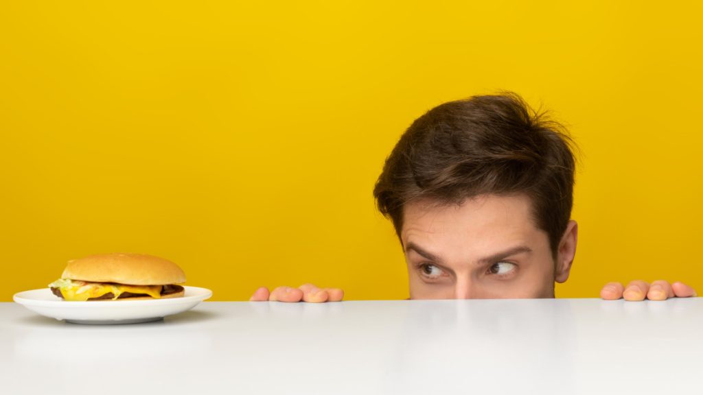 Hombre viendo una hamburguesa